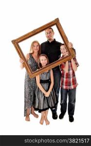 A young lovely family standing for white background and holding apicture frame in front of them.