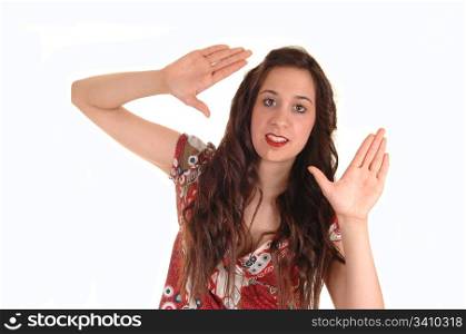 A young lovely woman giving a sign for taking a picture in a colorfuldress and long hair, over white background.