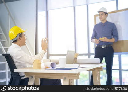 A young male and female engineer presenting the ideas and discuss plans to colleague in a meeting room, Group people business concept. young male and female engineer presenting the ideas and discuss plans to colleague in a meeting room, Group people business concept
