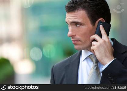 A young male executive on his mobile phone in a modern city