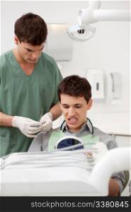 A young male patient in a dentist office looking at his teeth