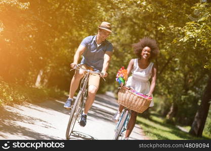 a young man and a beautiful African American girl enjoying a bike ride in nature on a sunny summer day