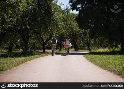 a young man and a beautiful black girl enjoying a bike ride in nature on a sunny summer day