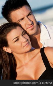 A young man and woman romantic couple at a beach, the focus is on the girl in the foreground.