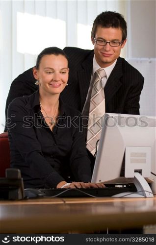 A young man and woman working together in a modern office