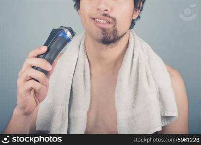 A young man cannot finish shaving because his electric razor is broken