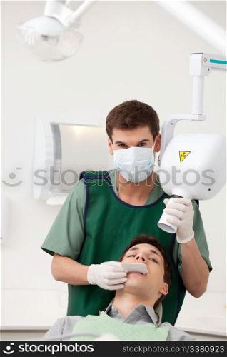 A young man dentist preparing an x-ray