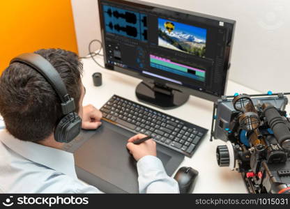 a young man designer using graphics tablet for video editing