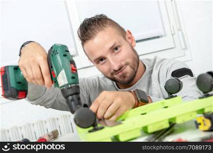 a young man DIY using electric drill