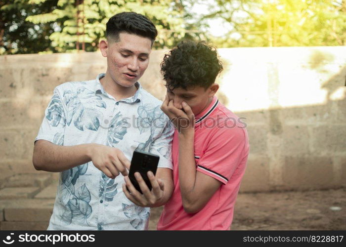 A young man explaining with his cell phone to a young man, A young man showing his cell phone to another young man