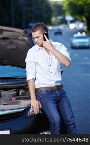 A young man explains on the phone about car breakdown