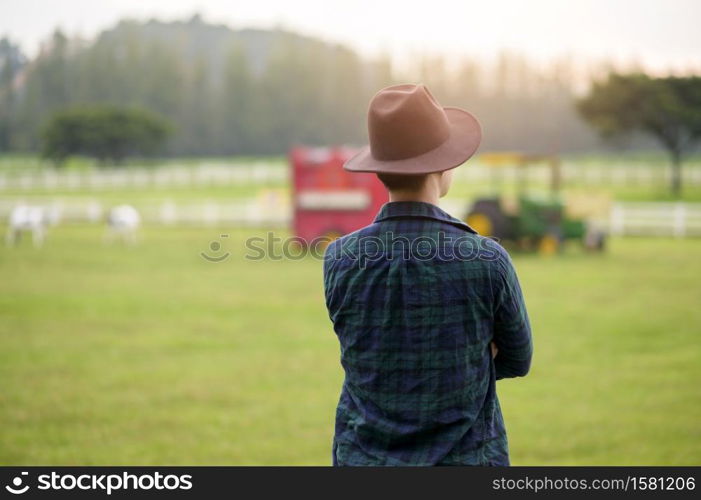 A young man farmer working on Beautiful landscape of country field at dawn