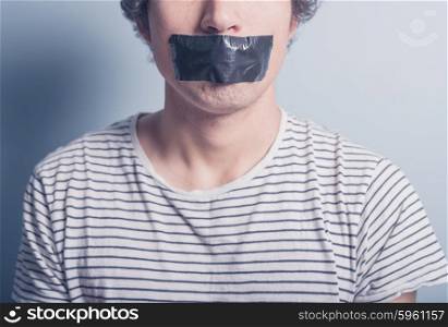 A young man has a big piece of black industrial tape covering his mouth