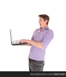 A young man holding his laptop and is surprised what he see&rsquo;s at thescreen on his computer, isolated for white background..