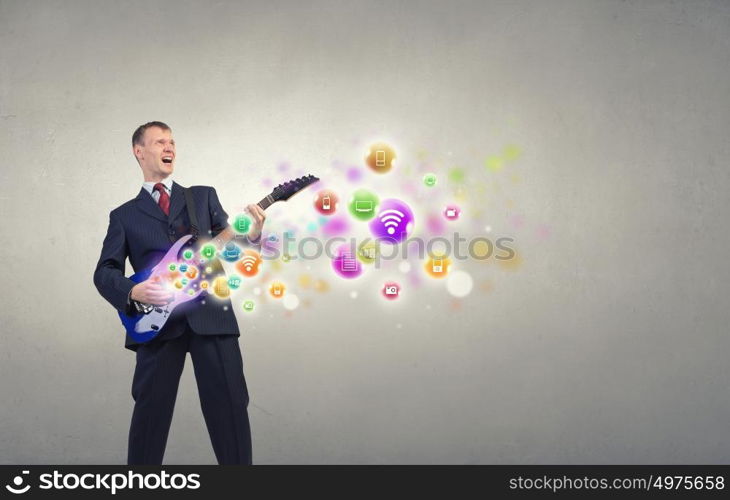 A young man in a black suit playing electric guitar. Man play guitar