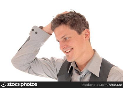 A young man in a grey shirt and vest scratching his head, wondering what is going on, isolated for white background.