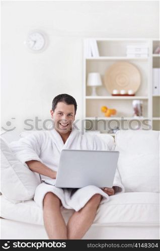A young man in a white robe with laptop