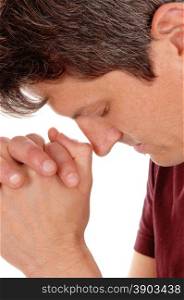 A young man in closeup, with his head bowed and hands folded, praying,isolated for white background.