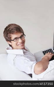 A young man in glasses with a laptop