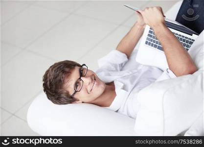 A young man in glasses with a laptop