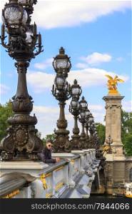A young man in Paris on the bridge of Alexander III in Paris, France