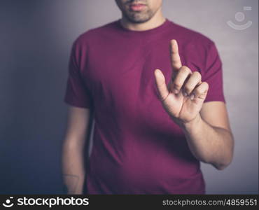 A young man in purple is raising his finger to swipe, push or establish authority