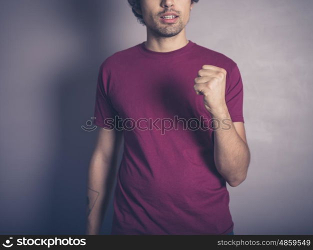 A young man in purple is winning and displaying an awesome fist pump