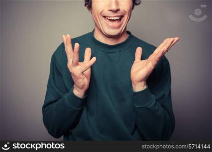 A young man is gesturing and pulling silly faces