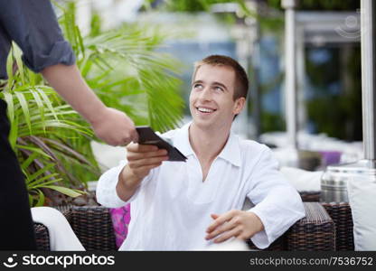 A young man is paying the price in a restaurant