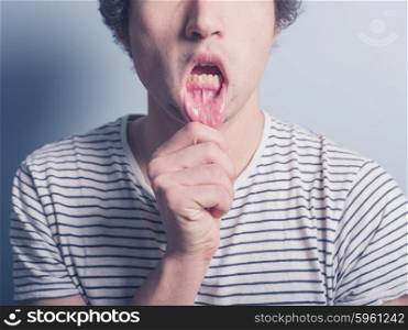 A young man is pulling his lower lip and is acting silly