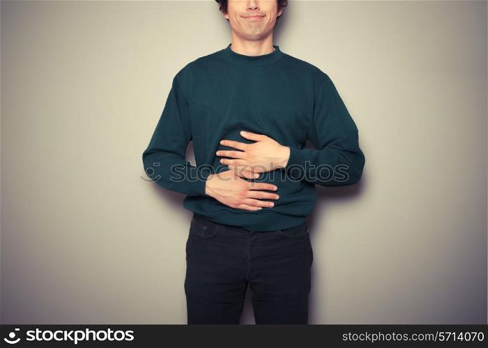 A young man is rubbing his stomach
