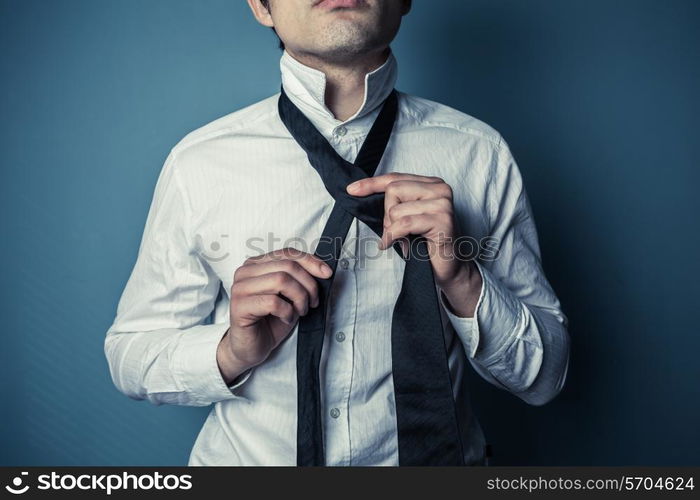 A young man is showing how to tie a necktie