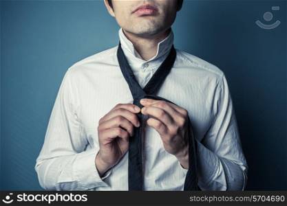 A young man is showing how to tie a necktie