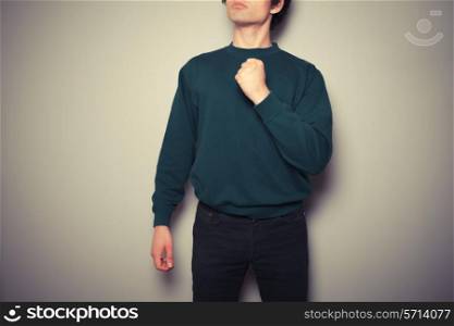 A young man is standing in a powerful pose
