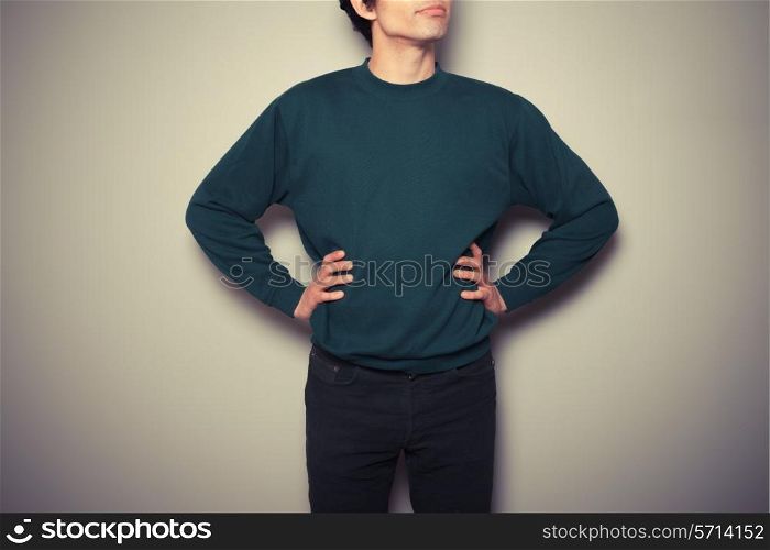 A young man is standing in a powerful pose