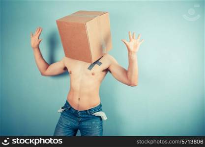 A young man is standing with a cardboard box on his head