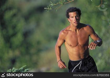 A young man jogging in a forest