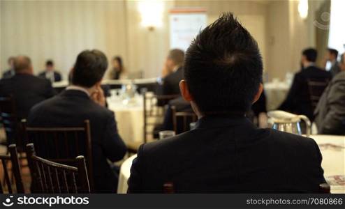 A young man listens at a business event