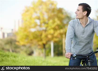 A young man on a bicycle looks into the distance