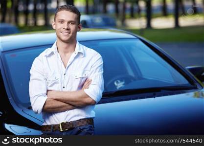 A young man on the background of cars