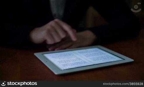 A Young Man Reading A Book On Tablet PC