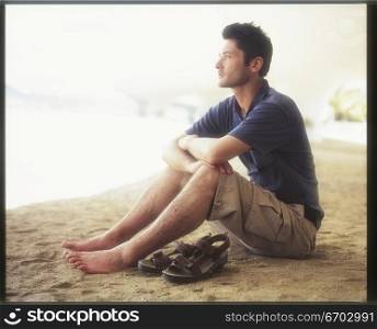 A young man relaxes by the sea.