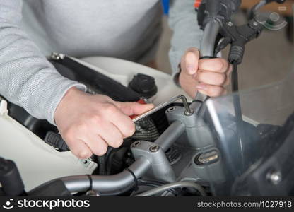 a young man repairing the motorcycle