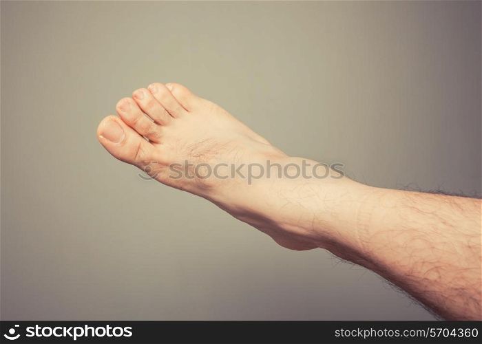 A young man&rsquo;s foot against a plain background