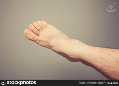 A young man&rsquo;s foot against a plain background