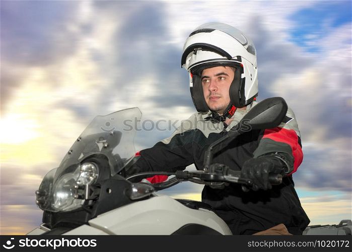 a young man sits on a motorcycle and has a helmet on his head