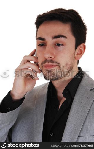 A young man talking on a cell phone in a black shirt and red tie with a beard,isolated for white background.