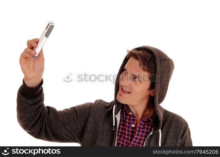 A young man wearing a hoody and taking a picture of himself witha cell phone, isolated for white background.