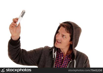 A young man wearing a hoody and taking a picture of himself witha cell phone, isolated for white background.