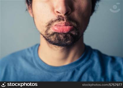 A young man with a beard is pulling silly faces